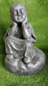 jeune moine assis sur un rocher